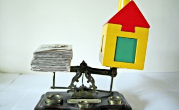 money and house in a scale 